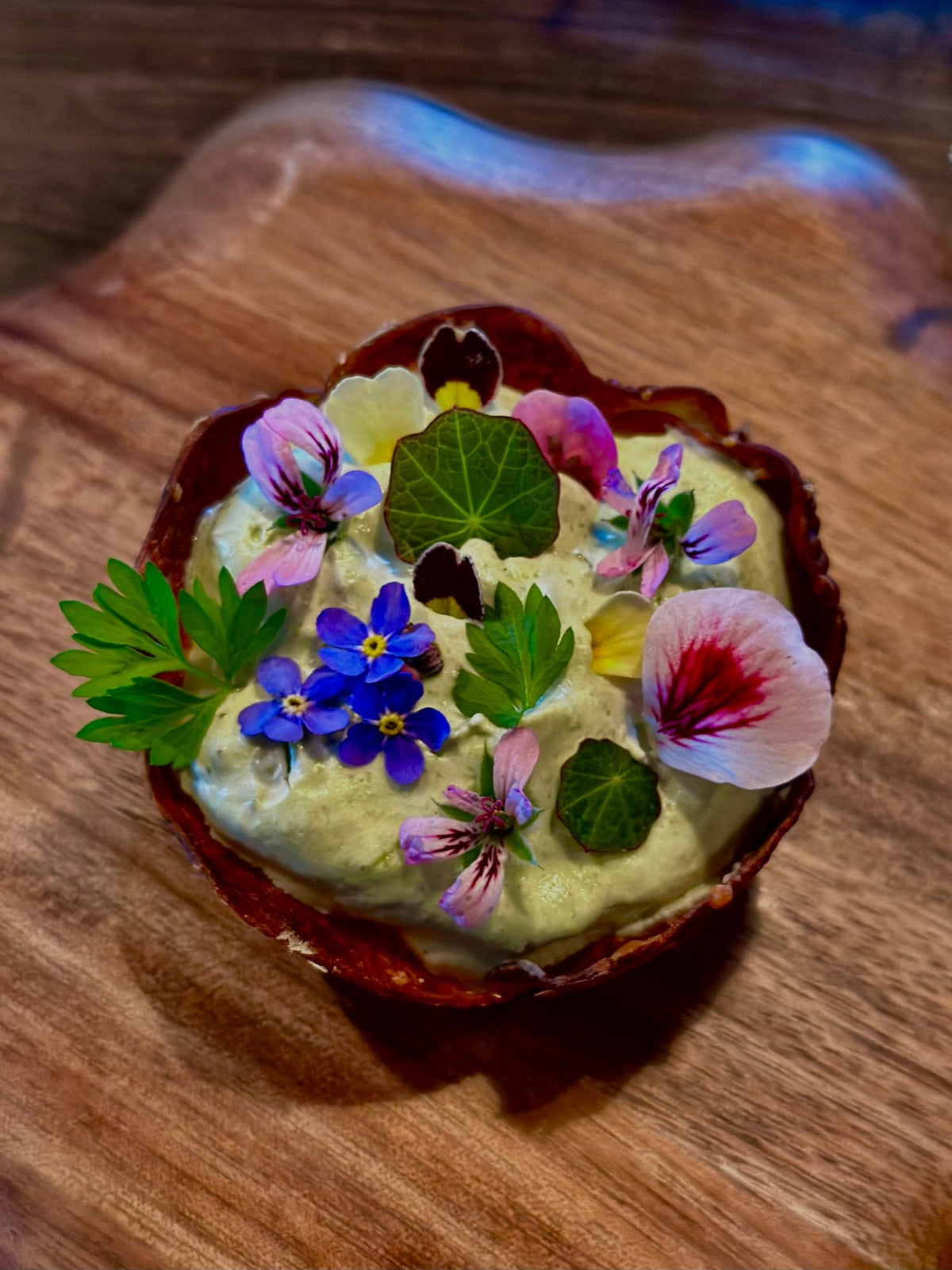 Bilde av potetmos pyntet med spiselige blomster plukket på brokkestøylen i setesdal.